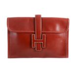 Hermes, Jige, a red leather clutch bag,   the fold over flap with  H logo as a closer , with a