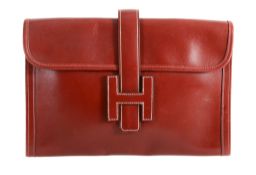 Hermes, Jige, a red leather clutch bag,   the fold over flap with  H logo as a closer , with a