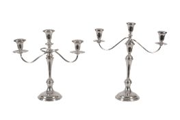 A pair of American weighted silver coloured three light candelabra by Cartier, stamped marks, in the