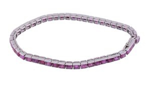 A ruby bracelet,   the channel set step cut rubies in articulated settings, with French poincons to