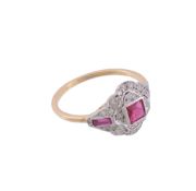 A ruby and diamond ring,   the central step cut ruby collet set within a surround of brilliant cut