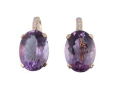 A pair of amethyst and diamond earrings,   the oval shaped facetted amethyst in a claw setting,
