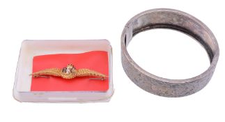 A bangle,   the hinged bangle with foliate engraving, to a concealed clasp, 5.7cm inner diameter;