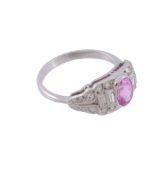 A pink sapphire and diamond ring,   the central oval shaped pink sapphire collet set within a