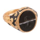 An early Victorian enamelled mourning ring,   the ring with an oval banded onyx panel carved with a