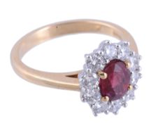 A ruby and diamond cluster ring,   the central oval shaped ruby in a four claw setting within a