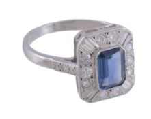 A sapphire and diamond ring,   the central rectangular shaped sapphire collet set within a surround