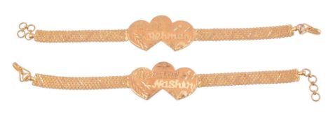 Two gold coloured bracelets  , each with a double heart shaped panel to a woven bracelet strap,