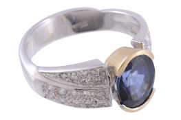 A sapphire and diamond ring,   the central oval shaped sapphire half collet set between brilliant