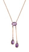 An amethyst pendant,   the oval shaped amethyst in a collet setting suspending two pear shaped