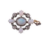 An opal and diamond brooch/pendant,   the central oval cabochon opal claw set within a surround of