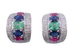 A pair of ruby, sapphire, emerald and diamond earrings,   the central oval shaped emerald between