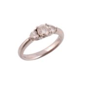 A three stone diamond ring,   the brilliant cut diamond flanked by heart shaped diamonds,