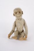 An early 20th Century plush monkey with animated head and wagging tail.