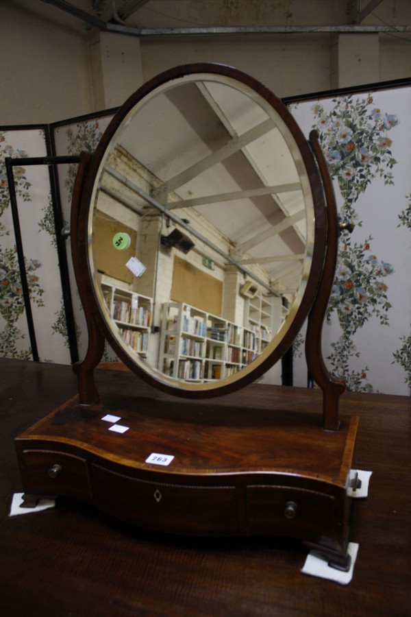 A George III mahogany toilet mirror, raised on serpentine base with satinwood stringing, fitted with