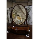 A George III mahogany toilet mirror, raised on serpentine base with satinwood stringing, fitted with