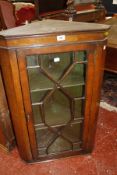A mahogany corner cupboard with astragal glazed door enclosing painted shelves 86cm high, 55cm wide