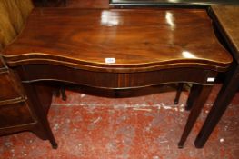A George III mahogany card table with a serpentine front enclosing baize lining on square tapering