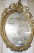 A giltwood and composition wall mirror, with an oval frame 87cm high, 59cm wide