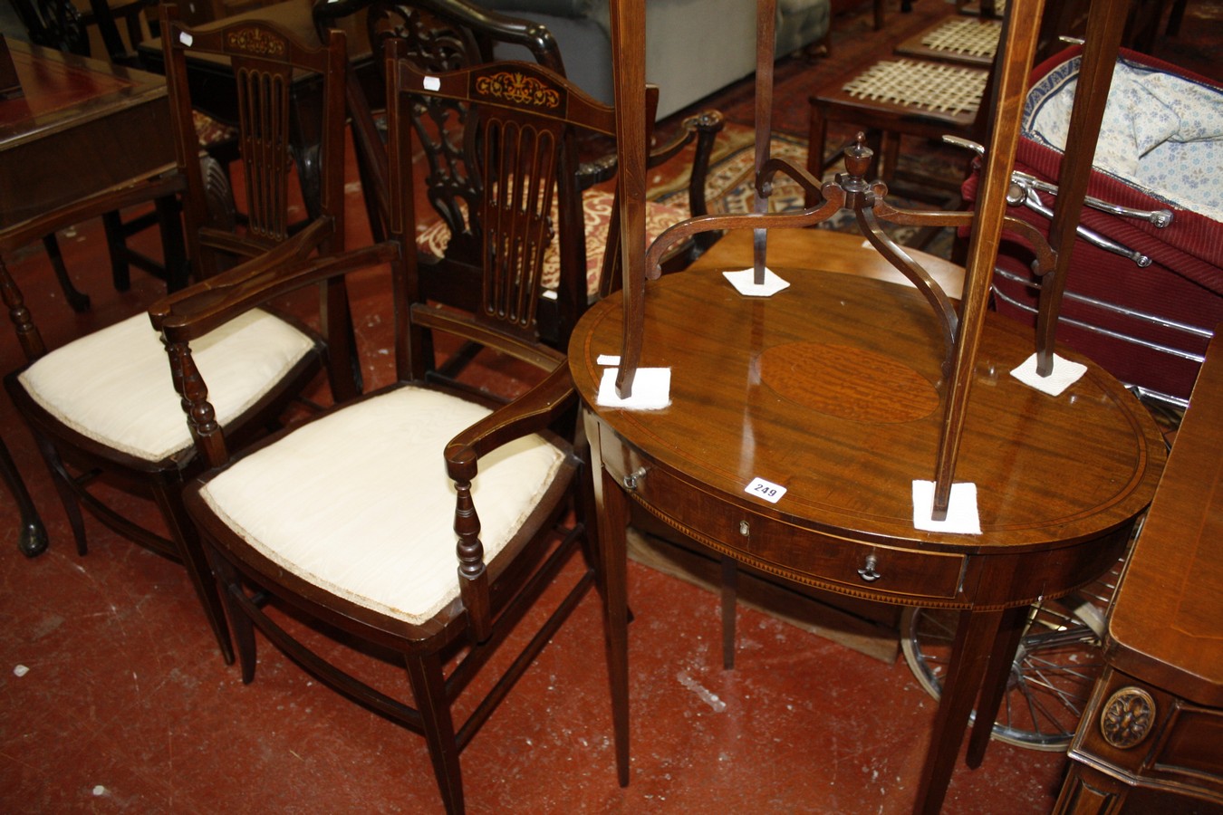 An Edwardian mahogany and inlaid oval table, two Edwardian elbow chairs and an oval table