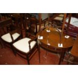 An Edwardian mahogany and inlaid oval table, two Edwardian elbow chairs and an oval table