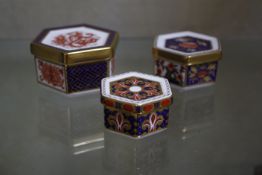 Three Royal Crown Derby hexagonal trinket boxes (A 1297 4cm wide, A 1295 5.5cm wide, A 1298, 5cm