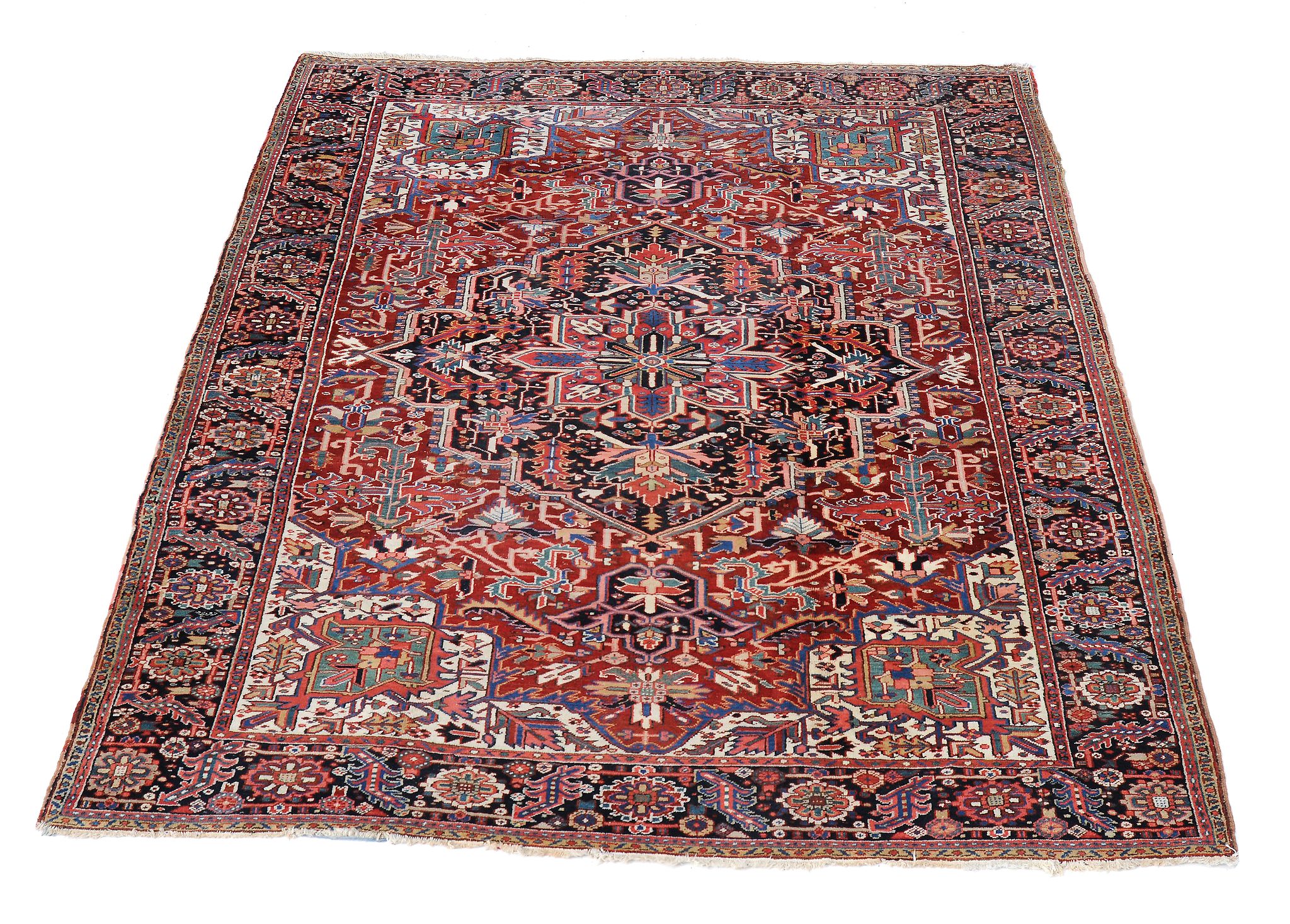 A Heriz carpet,   decorated with abstracted foliate motifs throughout, the central navy medallion