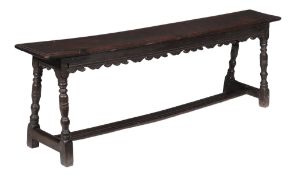 A Charles I oak long stool or bench  , circa 1630, the rectangular seat with moulded edge above a