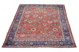 A Tabriz carpet,   of overall design, the madder field decorated with large flowerheads and