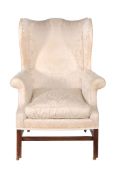 A George III mahogany wing armchair  ,  circa 1760, the shaped rectangular back above overscrolling