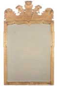 A George I giltwood and gesso wall mirror  , circa 1720, the shaped bevelled plate within a