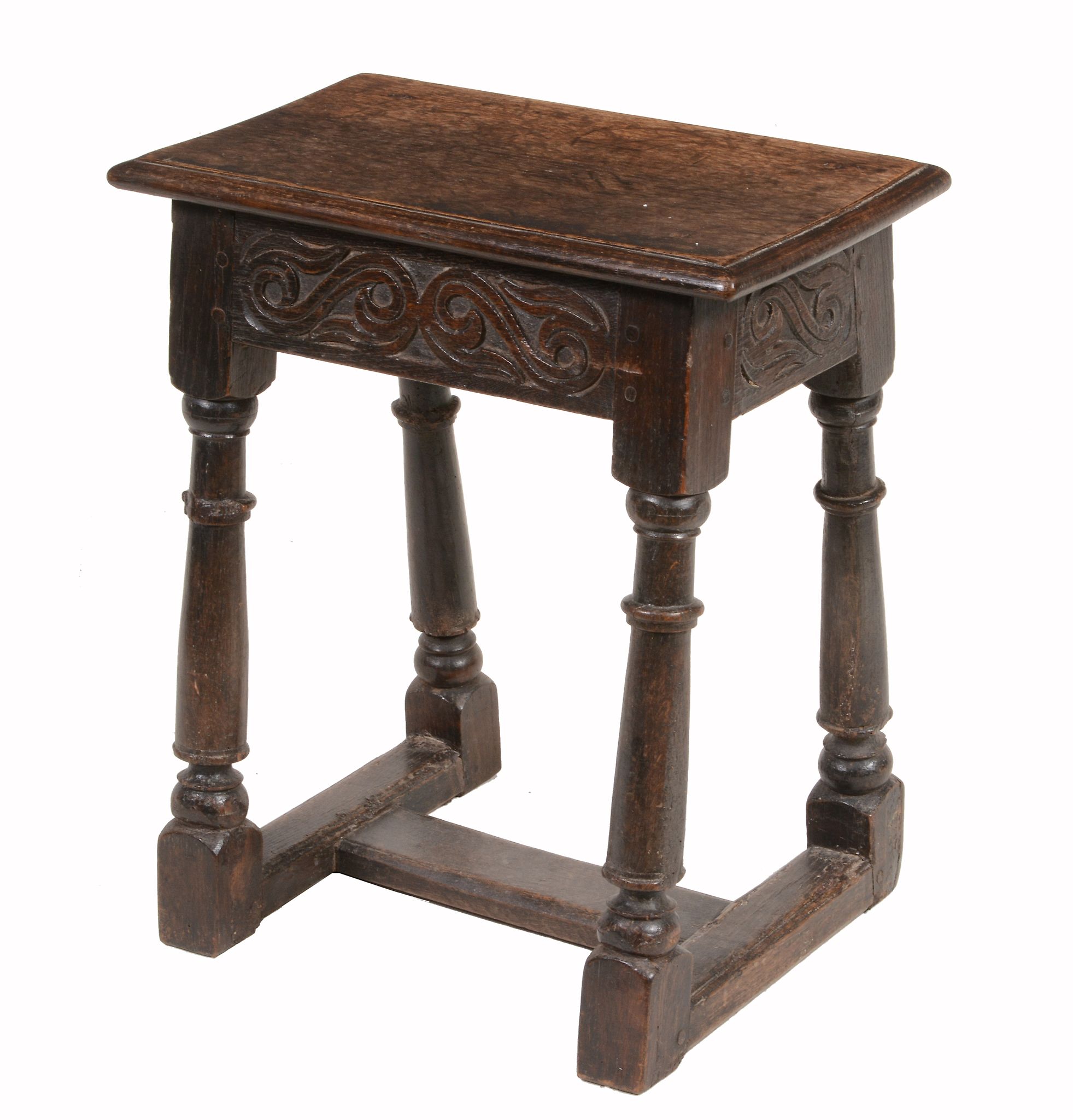 A Charles II oak joint stool  , circa 1660, the seat with moulded edge above a freize with scroll