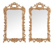 A pair of George III carved giltwood wall mirrors,   circa 1770, each shaped rectangular plate