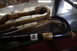 A quantity of walking sticks and rules to include one stick with 18ct gold mount inscribed '