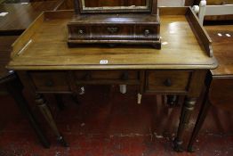 A 19th Century mahogany kneehole table with a three quarter gallery, three frieze drawers on