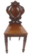 A pair Victorian mahogany hall chairs with carved back and facetted tapering legs