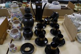 Four items of Poole Pottery; a Portmerion black and gilt part coffee set, two Prinknash pottery jugs