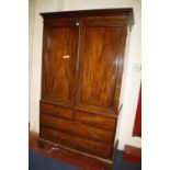 A 19th century mahogany linen press with a pair of panel doors enclosing linen slides, above two