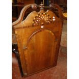 An oak and parquetry hanging corner cabinet with swan neck and inlaid pediment enclosing shelves