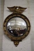 A Regency style gilt convex mirror with eagle cresting 70cm high, 47cm wide