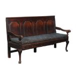 A George II oak panel back settle, circa 1740 and later, the quadruple panel back leading to open