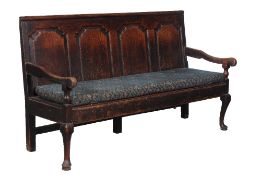 A George II oak panel back settle, circa 1740 and later, the quadruple panel back leading to open