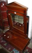 An Empire style mahogany toilet mirror with an arched pediment and bevelled plated flanked by