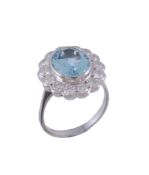 An aquamarine and diamond ring,   the central oval shaped aquamarine collet set within a surround