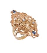 A sapphire and diamond dress ring,   the pierced panel with a central foliate design, set with an