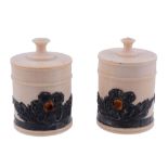 A pair of ivory cylindrical boxes,   circa 1900, with turned finials to the flat pull-off cover,