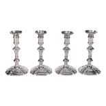 A set of four early George II cast silver shaped square candlesticks by...  A set of four early