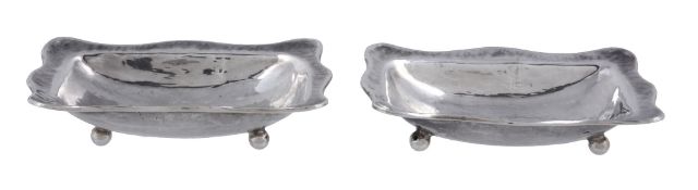 A pair of Arts and Crafts hammered silver salt cellars by Omar Ramsden  A pair of Arts and Crafts