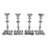 A matched set of four late George II cast silver shaped square candlesticks...  A matched set of