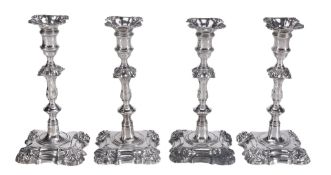 A matched set of four late George II cast silver shaped square candlesticks...  A matched set of